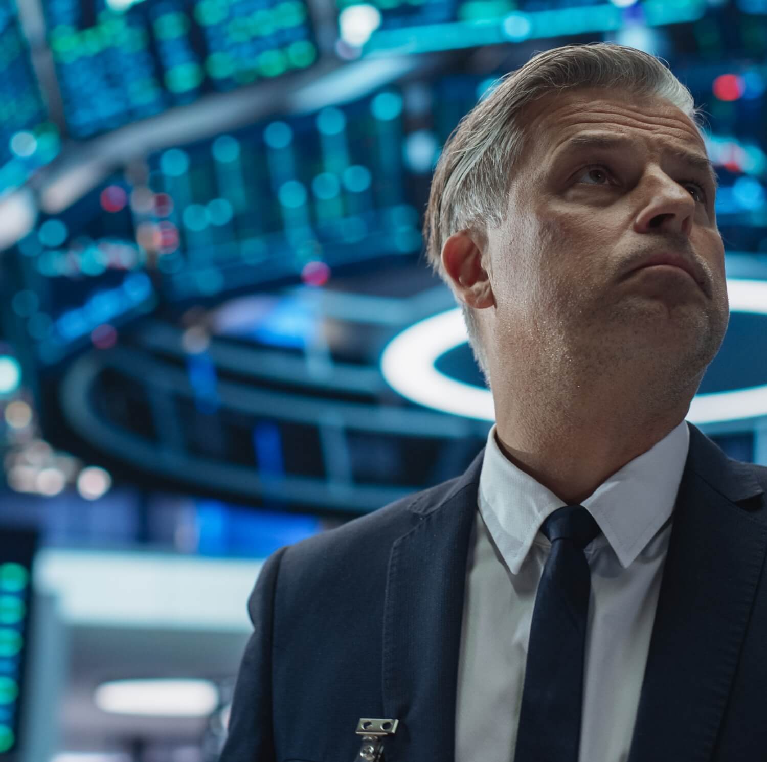 A trader looks up at market data on a screen